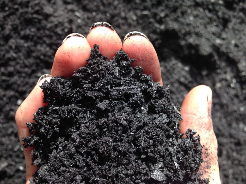 Farmer spreading biochar on fields to improve soil health and sequester carbon