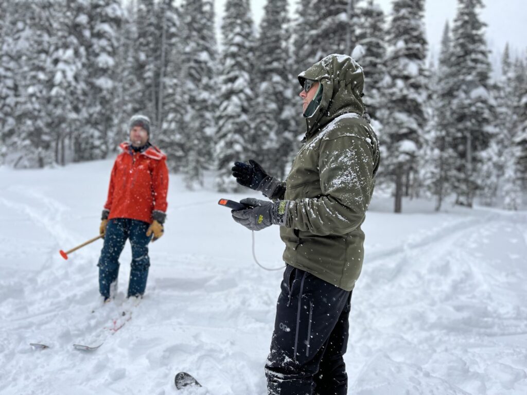 Conservation team clearing snow and inspecting a winter trail with tools