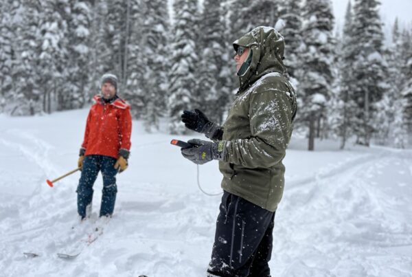 Conservation team clearing snow and inspecting a winter trail with tools