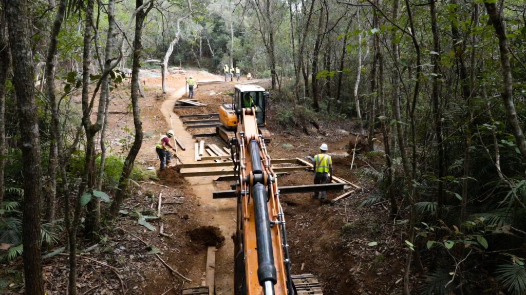 Surety bonds for trail construction projects – workers building sustainable path with Conservation United protection