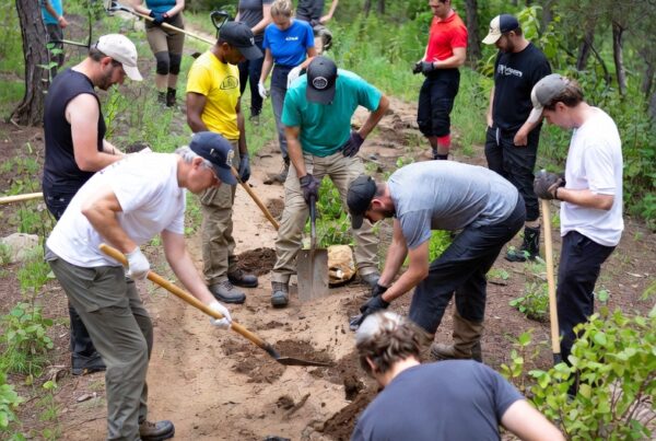 Diverse Friends Group volunteers conducting trail cleanup and habitat preservation in a national park