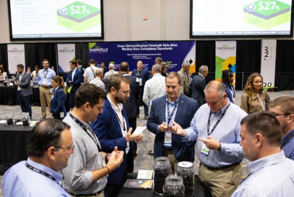 Attendees at the 2026 North American Biocarbon Conference in Nashville examining biochar samples while reviewing digital displays on carbon market integrity and quality differentiation
